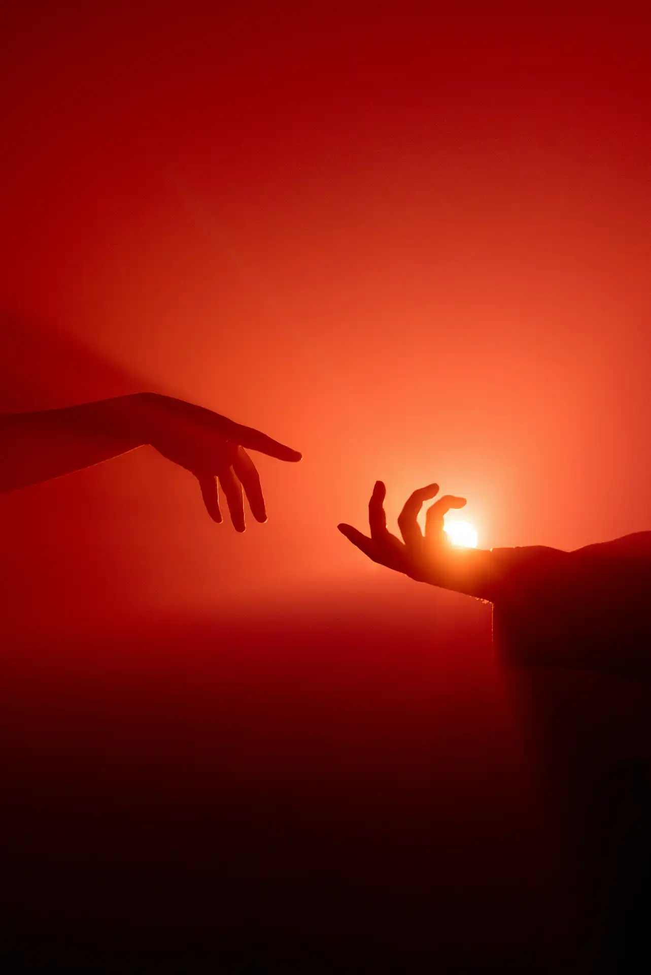 Nuvoki studio — two hands reaching toward each other against a warm red background